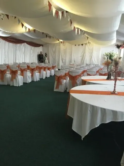 The hall dressed in warm orange tones for a ceremony